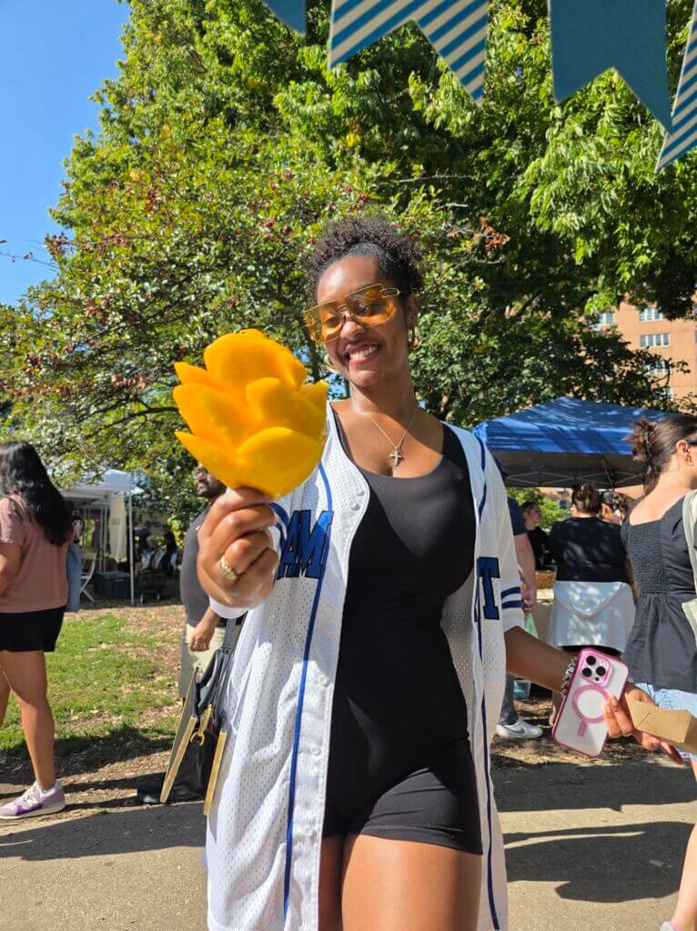 Happy shopper holding fresh yellow pepper at Wicker Park Farmers Market